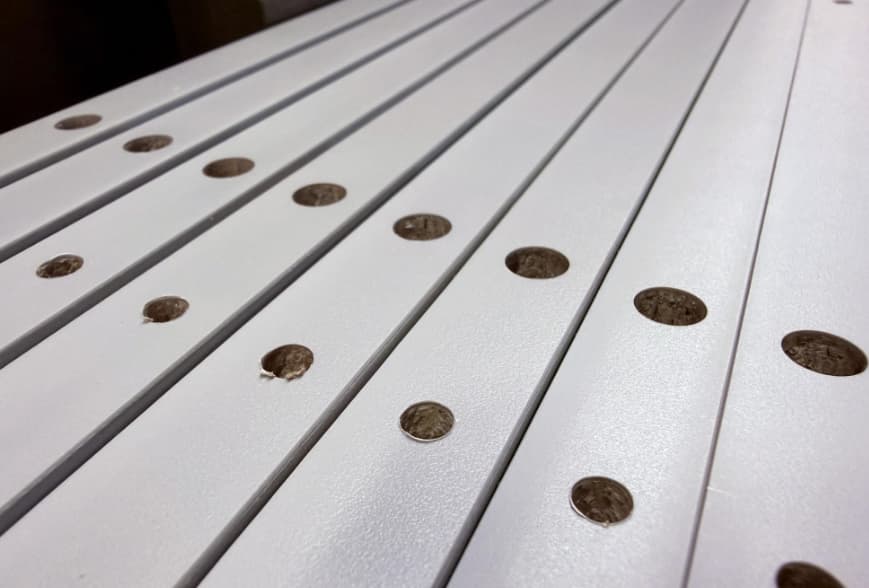 A CNC router equipped with a drilling unit can drill holes in furniture and cabinet panels.