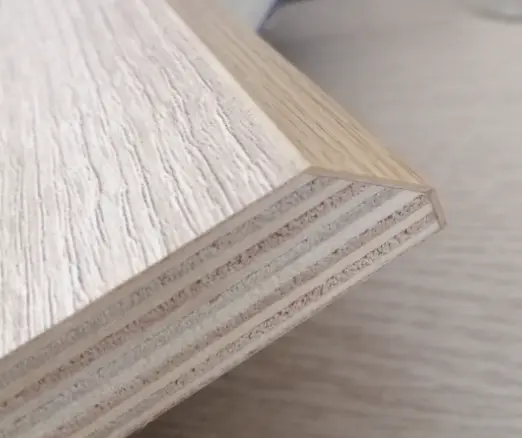 A custom table with intricate mitered corners and real wood veneer edging, highlighting fine woodworking precision