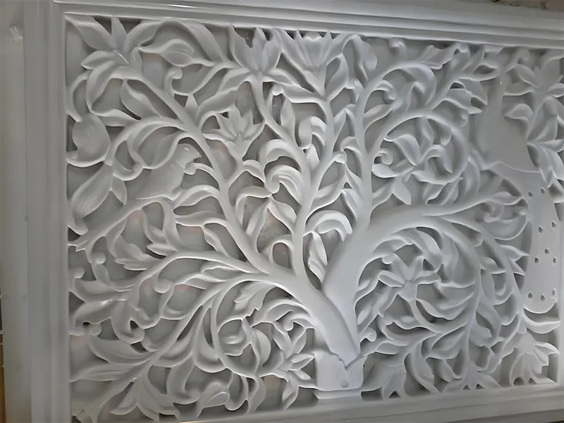 Intricate floral relief pattern carved into a marble wall panel by a computer-controlled CNC machine