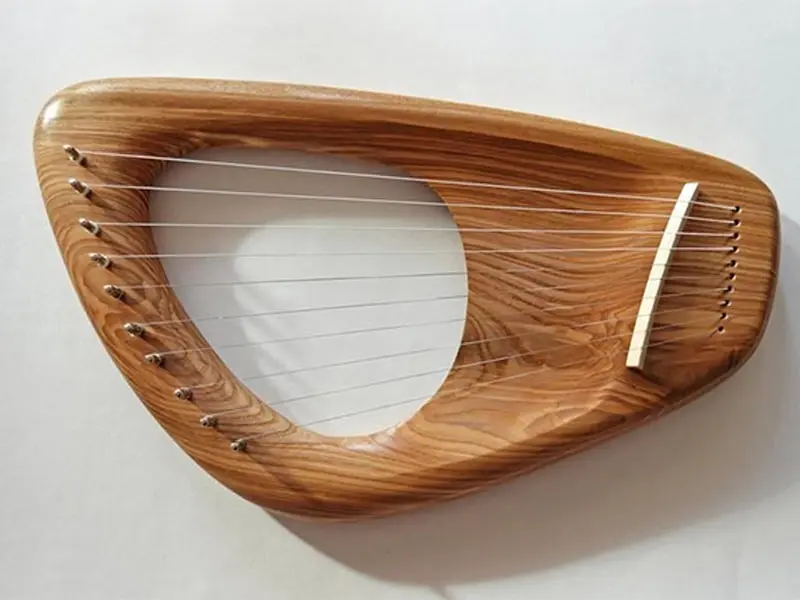 Polished metal resonator cover for a lap steel guitar, precision-stamped and engraved by a CNC machine